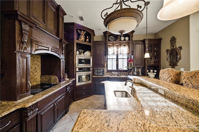1901 Pecos St, Mission, TX 78572 - kitchen with appliances with stainless steel finishes, light tile patterned floors, light stone countertops, and dark brown cabinetry