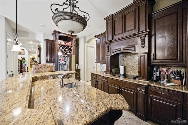 1901 Pecos St, Mission, TX 78572 - kitchen featuring arched walkways, decorative backsplash, black electric cooktop, stainless steel refrigerator with ice dispenser, and dark brown cabinets
