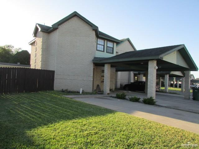 view of home's exterior featuring a carport and a lawn