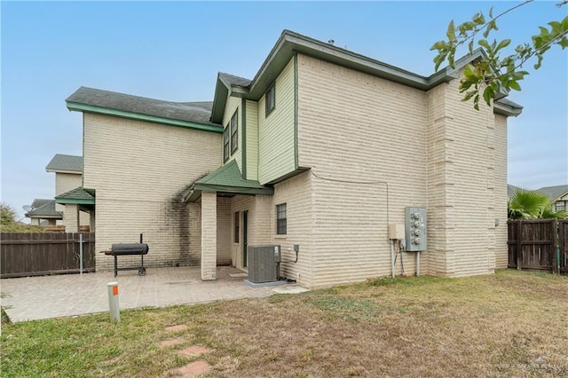 back of house with a yard, a patio, and central air condition unit