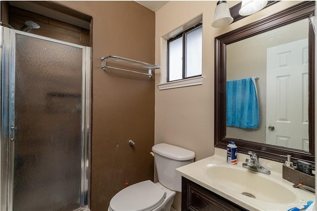 bathroom with vanity, toilet, and a shower with shower door