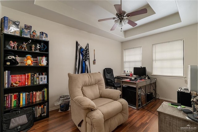 home office featuring ceiling fan, dark hardwood / wood-style floors, and a raised ceiling