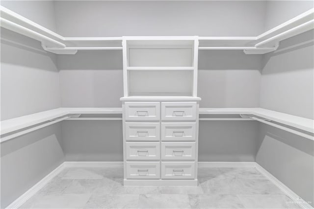 spacious closet featuring marble finish floor