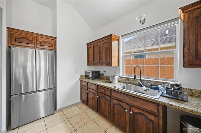 604 Hackberry Ave, Mission, TX 78572 - kitchen featuring freestanding refrigerator, vaulted ceiling, a sink, and light tile patterned flooring