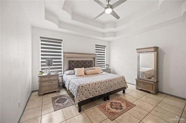604 Hackberry Ave, Mission, TX 78572 - bedroom with light tile patterned floors, baseboards, a tray ceiling, and ceiling fan