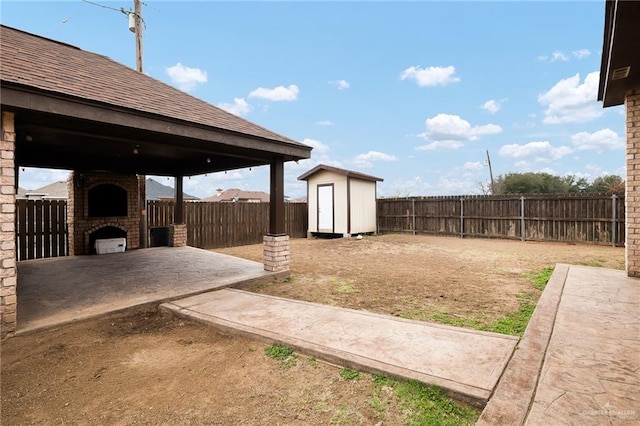 view of yard featuring a shed and a patio area