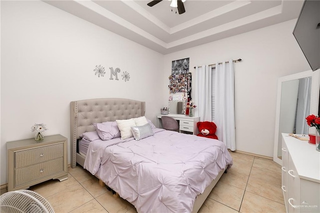 tiled bedroom with ceiling fan and a raised ceiling