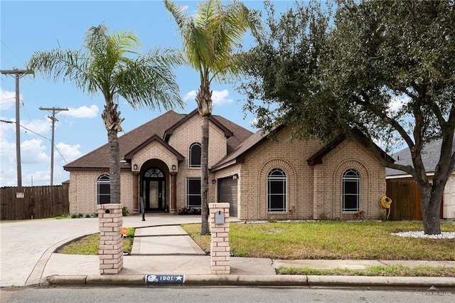 french provincial home with a garage and a front yard