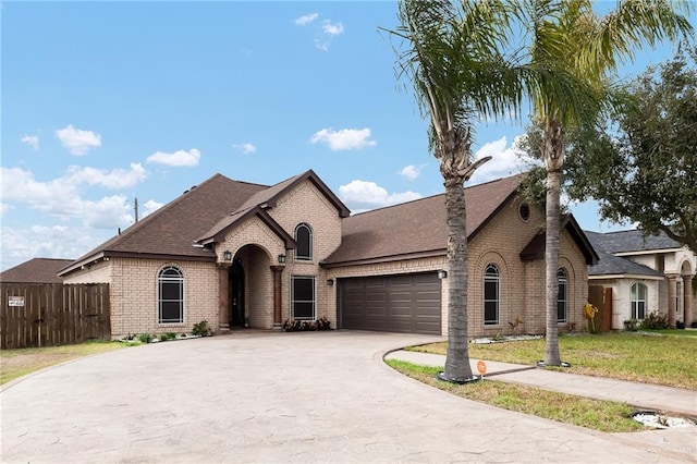 french country home with a garage and a front yard