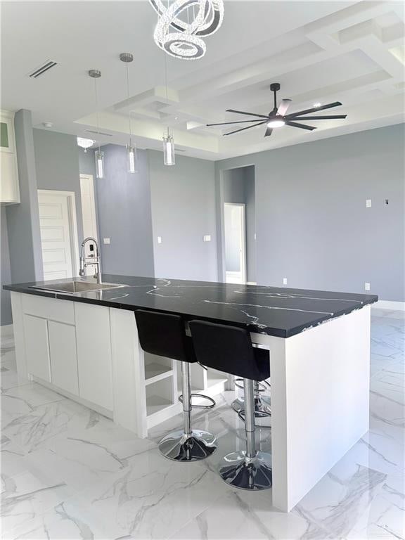 kitchen featuring white cabinetry, sink, hanging light fixtures, and a large island