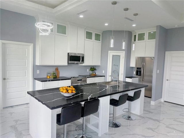 kitchen with pendant lighting, sink, an island with sink, and stainless steel appliances