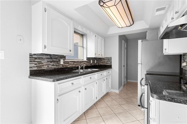 kitchen featuring tasteful backsplash, white cabinetry, stainless steel electric range oven, and sink