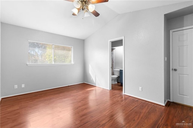 unfurnished bedroom featuring dark wood-type flooring, ceiling fan, vaulted ceiling, and ensuite bath