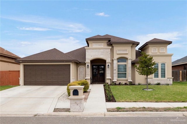 view of front of house featuring french doors, concrete driveway, an attached garage, fence, and a front lawn