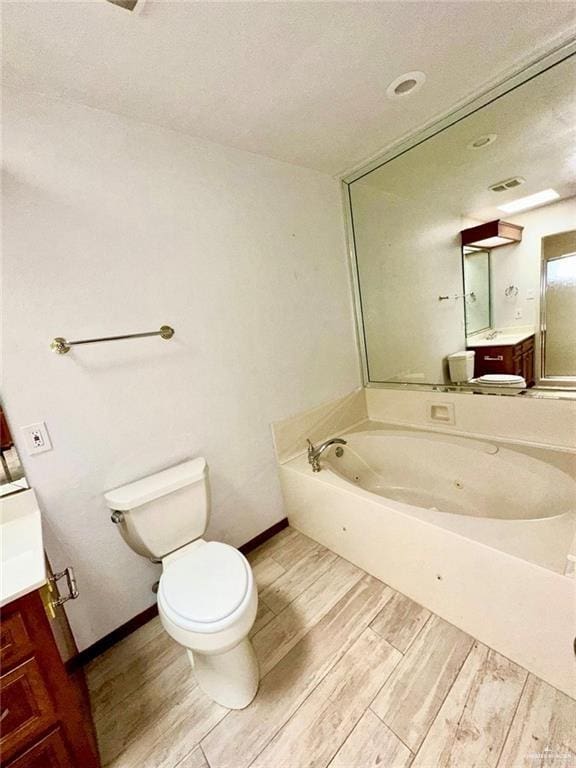 bathroom with wood-type flooring, vanity, toilet, and a bathtub