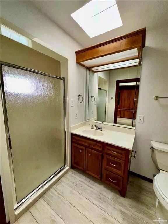 bathroom featuring vanity, hardwood / wood-style flooring, toilet, and a shower with door