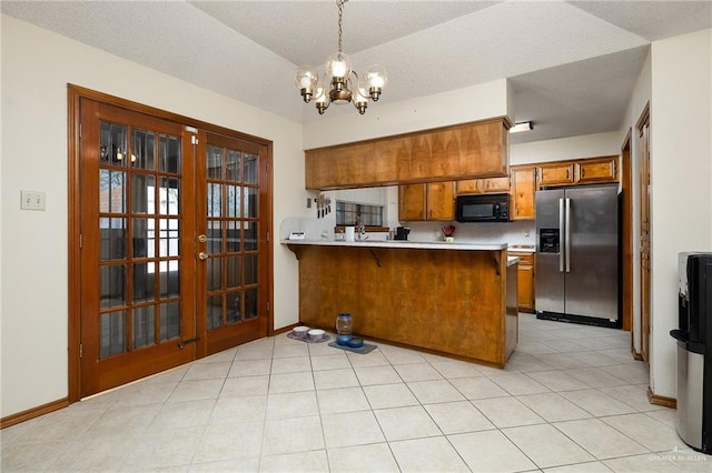 kitchen featuring light countertops, black microwave, brown cabinets, and stainless steel refrigerator with ice dispenser