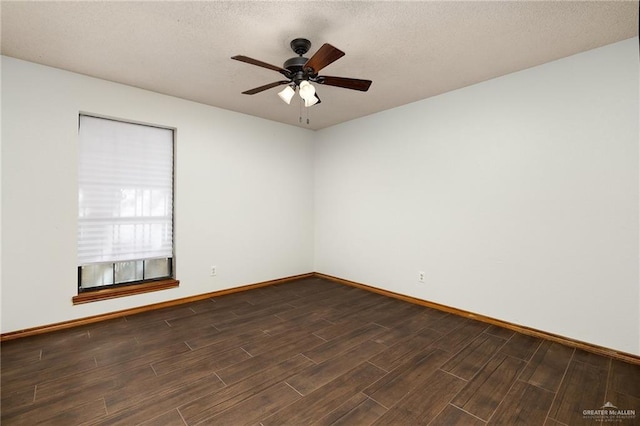 spare room featuring a textured ceiling, dark wood finished floors, a ceiling fan, and baseboards