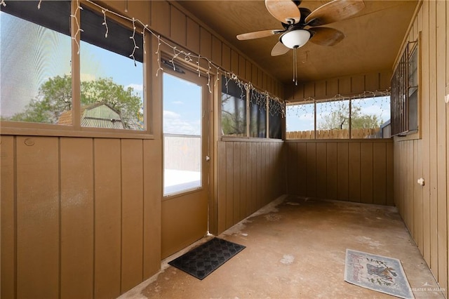 unfurnished sunroom featuring ceiling fan