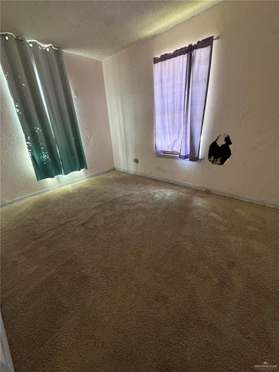 carpeted spare room with a textured ceiling