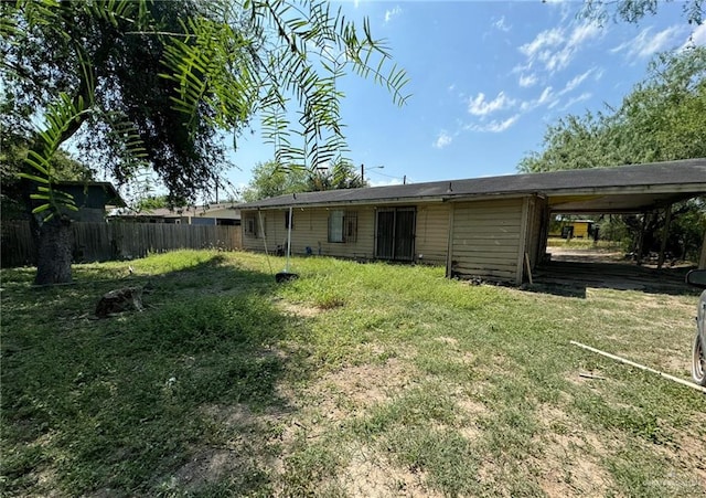 back of house featuring a carport and a yard