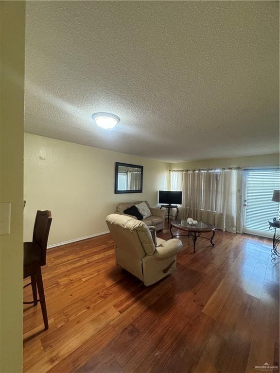 living room with hardwood / wood-style floors and a textured ceiling