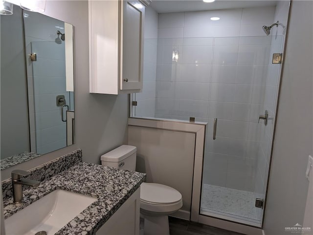 full bath featuring a stall shower, vanity, and toilet