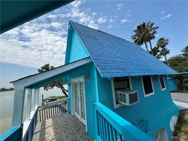 view of property exterior featuring cooling unit and french doors