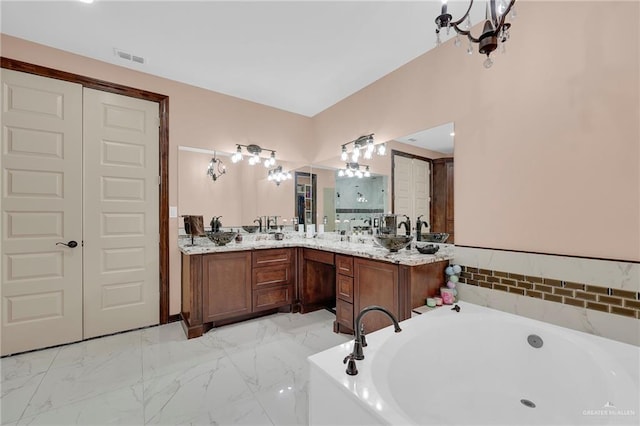 2000 Shelby St, Mission, TX 78572 - full bath featuring a garden tub, double vanity, a chandelier, and marble finish flooring