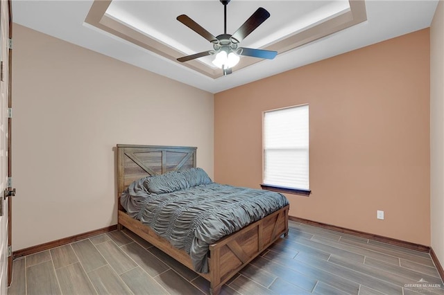 2000 Shelby St, Mission, TX 78572 - bedroom featuring a tray ceiling, baseboards, wood finish floors, and a ceiling fan