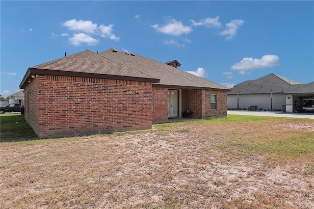 2000 Shelby St, Mission, TX 78572 - back of property featuring brick siding, a shingled roof, and a lawn