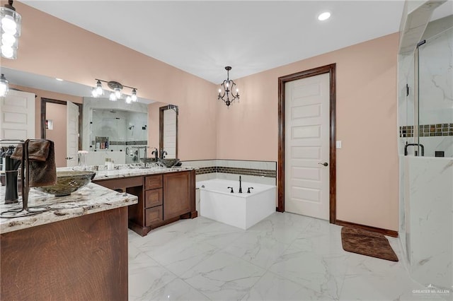 2000 Shelby St, Mission, TX 78572 - full bath with a marble finish shower, a garden tub, vanity, marble look tile flooring, and a chandelier