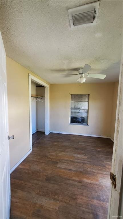 interior space featuring a textured ceiling, a closet, ceiling fan, and dark hardwood / wood-style floors