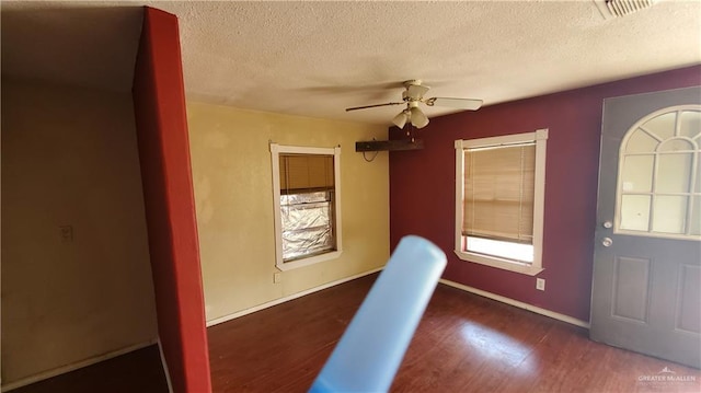 foyer entrance featuring dark hardwood / wood-style floors, ceiling fan, and a textured ceiling