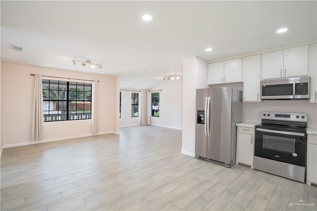 218 W Eller Ave, Pharr, TX 78577 - kitchen featuring stainless steel appliances, light countertops, open floor plan, light wood-type flooring, and white cabinetry