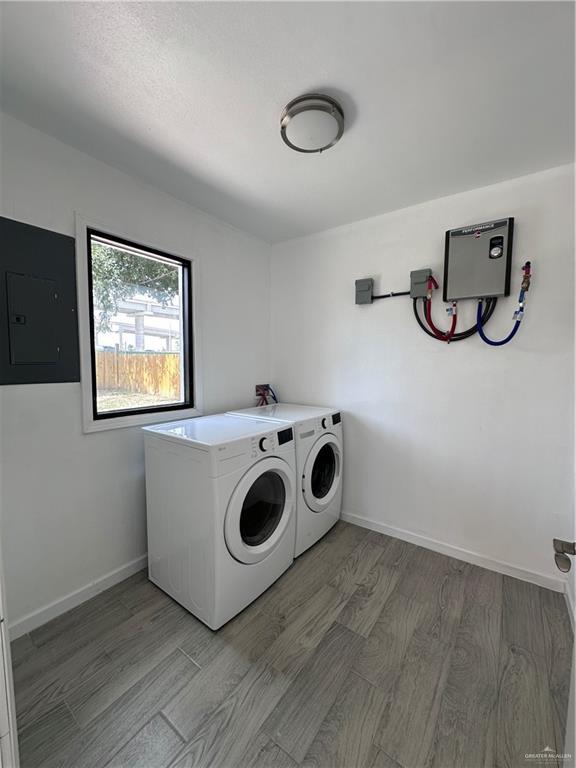 218 W Eller Ave, Pharr, TX 78577 - washroom featuring separate washer and dryer, light wood-style flooring, and electric panel