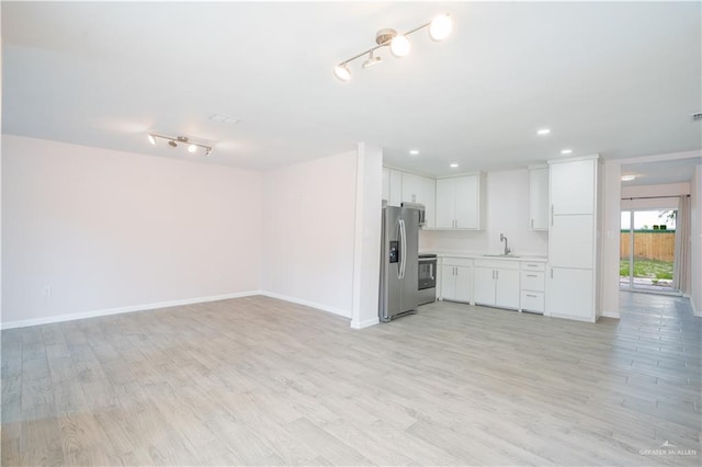 218 W Eller Ave, Pharr, TX 78577 - unfurnished living room featuring rail lighting, light wood-type flooring, and recessed lighting