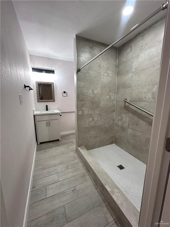 218 W Eller Ave, Pharr, TX 78577 - bathroom with vanity, a tile shower, and marble look tiles