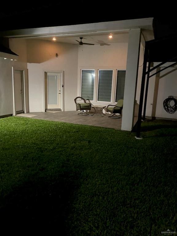 rear view of house featuring a patio, stucco siding, a ceiling fan, and a lawn