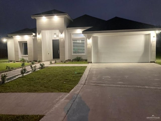 view of front of property featuring driveway, a garage, a lawn, and stucco siding