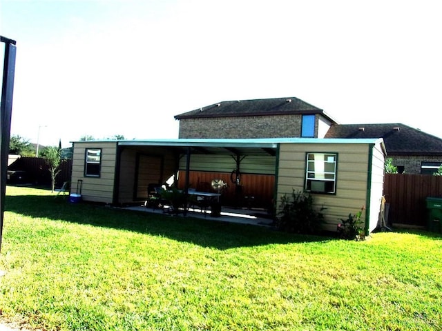 back of property featuring a lawn and fence