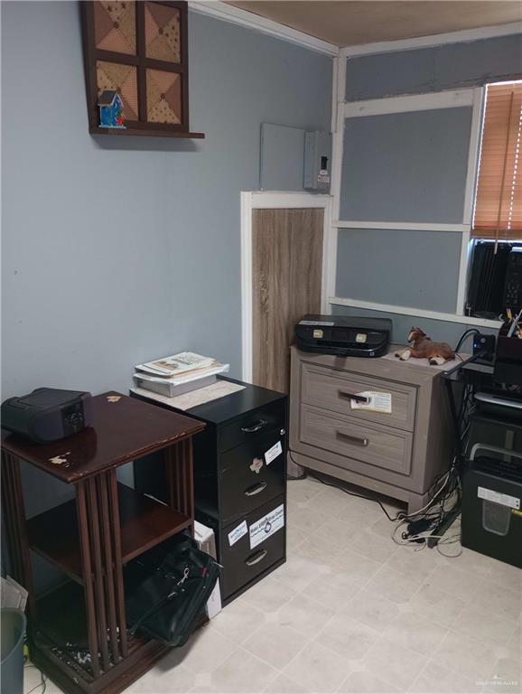 home office with light floors and ornamental molding