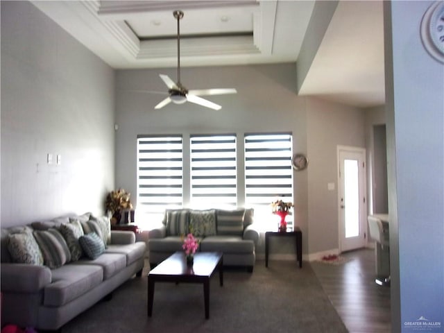 living room with a tray ceiling and ceiling fan