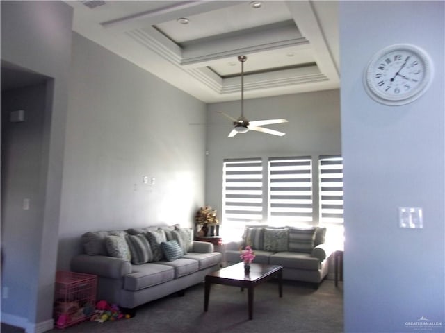 living room with ceiling fan, a raised ceiling, carpet floors, and a high ceiling