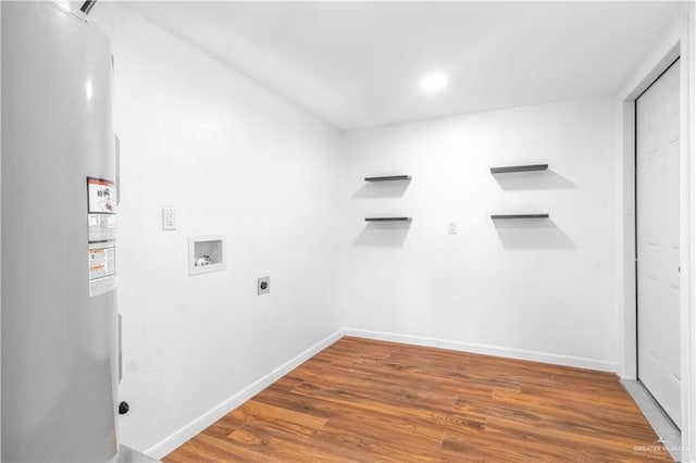 laundry room featuring water heater, hookup for a washing machine, hardwood / wood-style floors, and electric dryer hookup