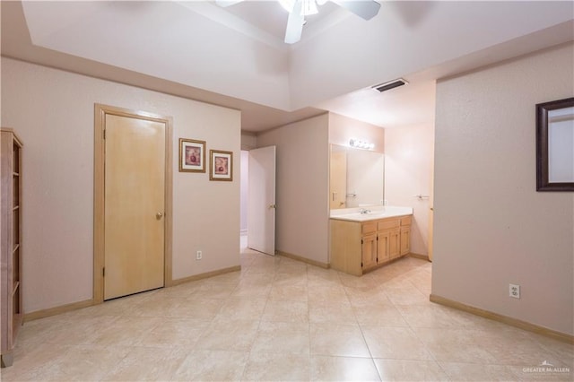 interior space with connected bathroom, ceiling fan, and sink