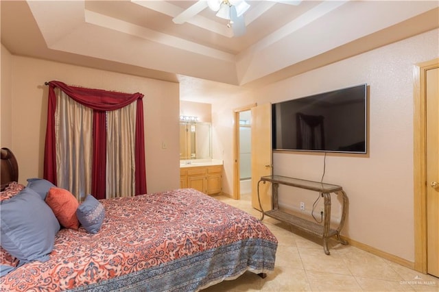 tiled bedroom featuring ceiling fan, ensuite bathroom, and a tray ceiling