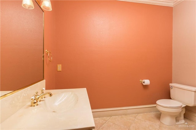 bathroom with tile patterned floors, toilet, ornamental molding, and sink