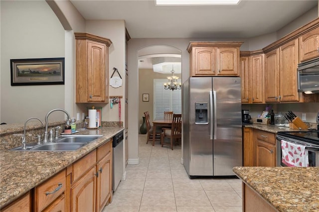 5109 Quince Ave, Mcallen, TX 78501 - kitchen with appliances with stainless steel finishes, a sink, arched walkways, a chandelier, and light tile patterned flooring