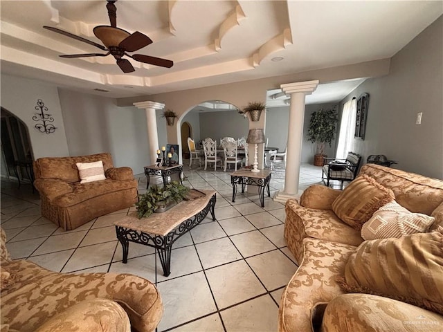 858 S La Homa Rd S, Mission, TX 78573 - living room featuring decorative columns, arched walkways, a tray ceiling, a ceiling fan, and light tile patterned floors